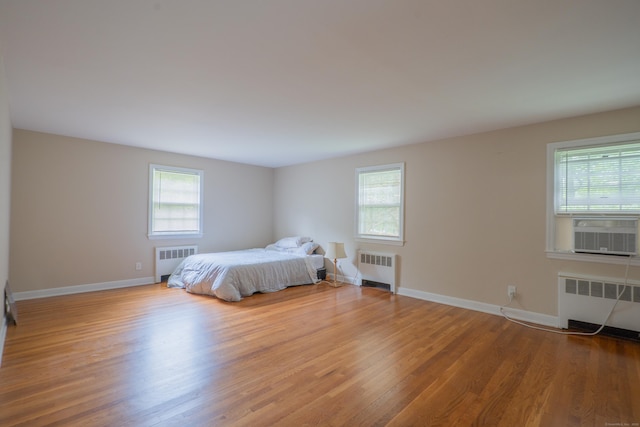 226 Stanwich Rd, Greenwich, CT 06830 - bedroom featuring multiple windows, wood finished floors, and radiator