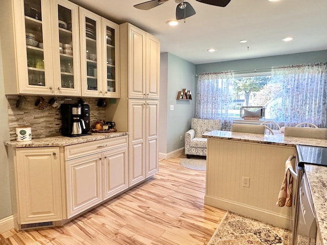 85 Viscount Dr Unit 4E, Milford, CT 06460 - kitchen featuring stove, a ceiling fan, light wood-style floors, tasteful backsplash, and light stone countertops