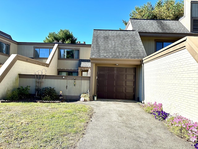 85 Viscount Dr Unit 4E, Milford, CT 06460 - view of front of house featuring a garage, a shingled roof, asphalt driveway, and brick siding