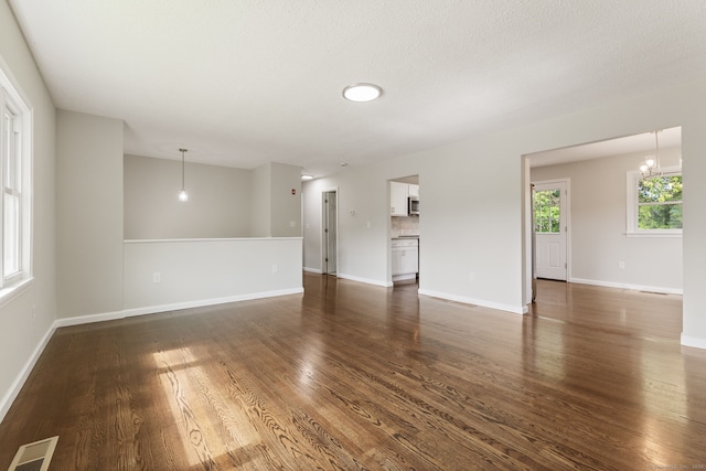 231 Lincolndale Dr, Waterbury, CT 06704 - unfurnished living room with dark wood-type flooring and a chandelier