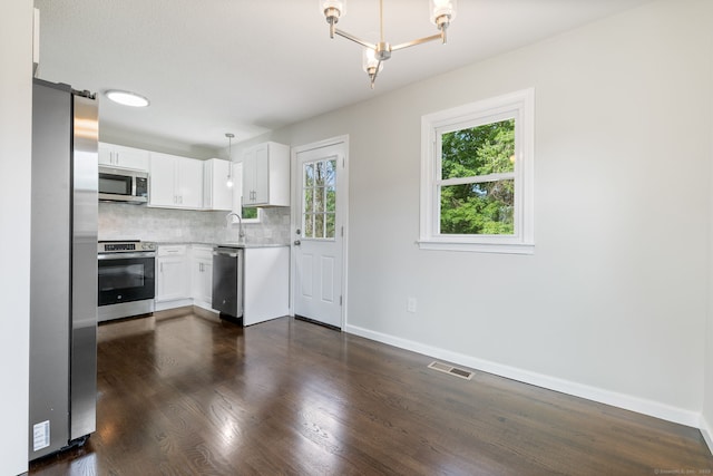 231 Lincolndale Dr, Waterbury, CT 06704 - kitchen with stainless steel appliances, backsplash, white cabinetry, dark wood-type flooring, and hanging light fixtures