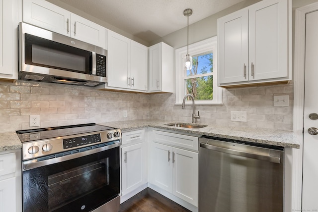 231 Lincolndale Dr, Waterbury, CT 06704 - kitchen featuring stainless steel appliances, white cabinets, and hanging light fixtures