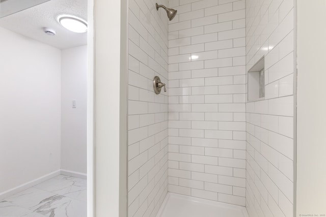 231 Lincolndale Dr, Waterbury, CT 06704 - bathroom featuring marble look tile flooring, tiled shower, and a textured ceiling