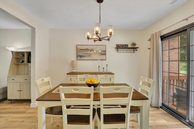 177 New Britain Ave Unit 177, Farmington, CT 06085 - dining area featuring light wood finished floors, a chandelier, and a textured ceiling