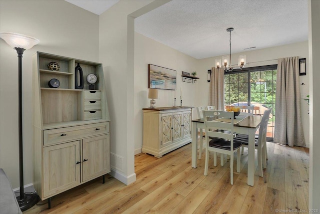 177 New Britain Ave Unit 177, Farmington, CT 06085 - dining room featuring light wood finished floors, a chandelier, and a textured ceiling