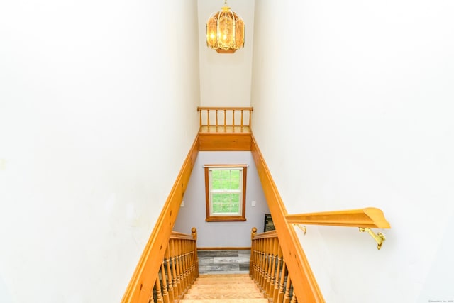 117 Woodside St, Putnam, CT 06260 - stairs featuring a chandelier, wood finished floors, and a towering ceiling