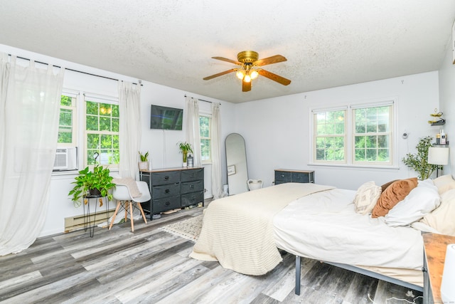 117 Woodside St, Putnam, CT 06260 - bedroom featuring wood finished floors, cooling unit, a textured ceiling, and ceiling fan