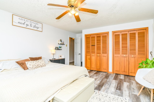 117 Woodside St, Putnam, CT 06260 - bedroom featuring two closets, light wood-style flooring, a textured ceiling, and a ceiling fan