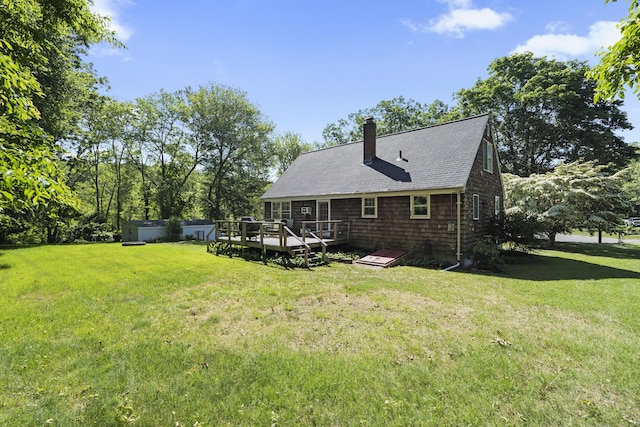 8 Nelson Dr, East Lyme, CT 06333 - rear view of house featuring a wooden deck, a chimney, roof with shingles, and a yard