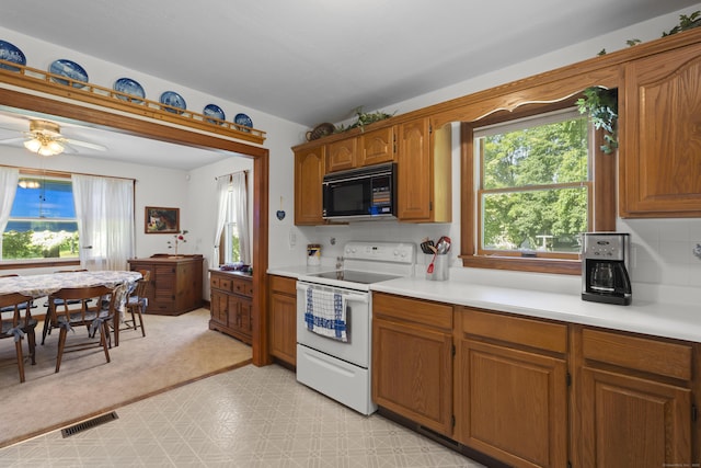 8 Nelson Dr, East Lyme, CT 06333 - kitchen featuring black microwave, electric stove, plenty of natural light, and light countertops