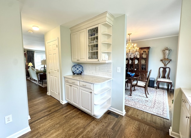 6005 Hancock Dr Unit 6005, Danbury, CT 06811 - bar with a chandelier, dark wood finished floors, tasteful backsplash, and crown molding