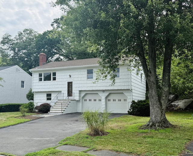 53 Valley View Rd, Norwalk, CT 06851 - split foyer home with driveway, a chimney, a garage, and a front lawn