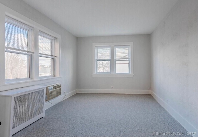 77 Glenbrook Rd Apt 203, Stamford, CT 06902 - empty room featuring radiator, light colored carpet, and a wall mounted AC