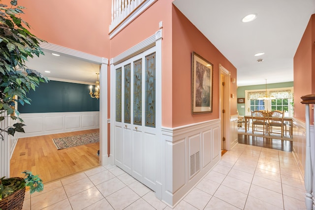 12 Marc Dr, Watertown, CT 06795 - hallway with a chandelier, light tile patterned flooring, a decorative wall, a wainscoted wall, and recessed lighting