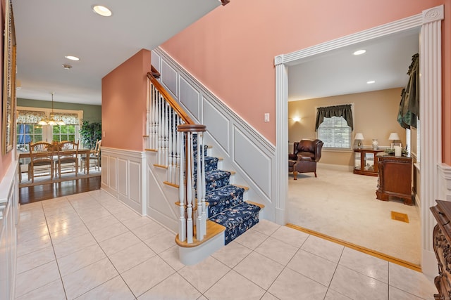 12 Marc Dr, Watertown, CT 06795 - stairs with a decorative wall, tile patterned flooring, a wainscoted wall, a chandelier, and recessed lighting