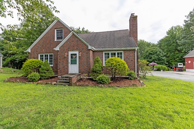 534 Norwich Ave, Colchester, CT 06415 - view of front of home with a front yard, a chimney, roof with shingles, and brick siding
