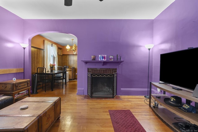 173 Euclid St W, Hartford, CT 06112 - living area featuring arched walkways, wood finished floors, a fireplace with flush hearth, a ceiling fan, and a chandelier