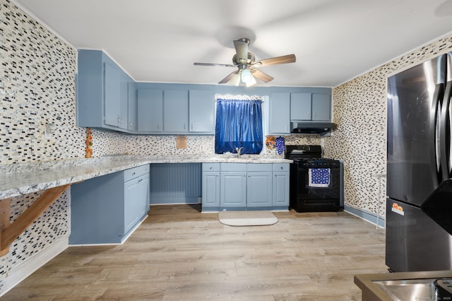 28 W High St, New London, CT 06320 - kitchen with black range with gas stovetop, freestanding refrigerator, and blue cabinetry