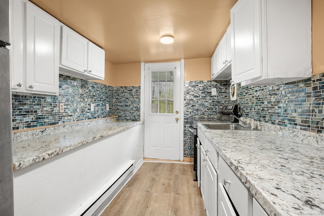 28 W High St, New London, CT 06320 - kitchen with light wood finished floors, white cabinets, backsplash, and a baseboard radiator