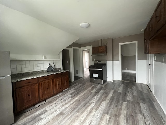 155 Summerfield Ave, Bridgeport, CT 06610 - kitchen featuring stainless steel gas stove, freestanding refrigerator, light wood finished floors, decorative backsplash, and lofted ceiling