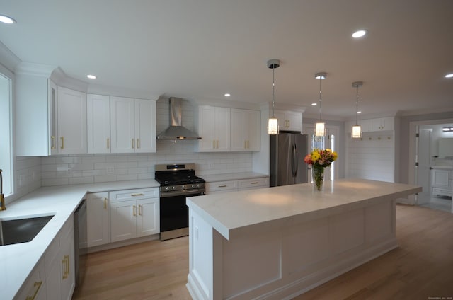 401 Unity Rd, Trumbull, CT 06611 - kitchen with appliances with stainless steel finishes, wall chimney exhaust hood, light wood-style floors, tasteful backsplash, and white cabinets