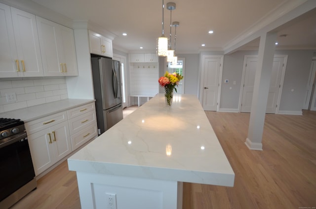 401 Unity Rd, Trumbull, CT 06611 - kitchen with stainless steel appliances, a center island, light wood-style floors, backsplash, and crown molding