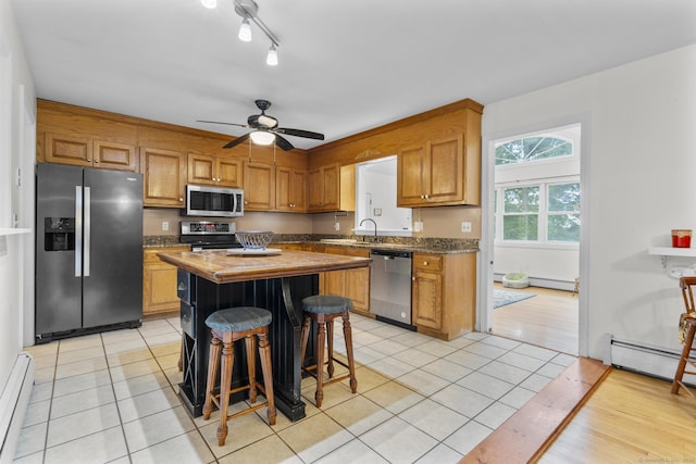 124 Pulaski Hwy, Ansonia, CT 06401 - kitchen with stainless steel appliances, light tile patterned flooring, a center island, baseboard heating, and a ceiling fan