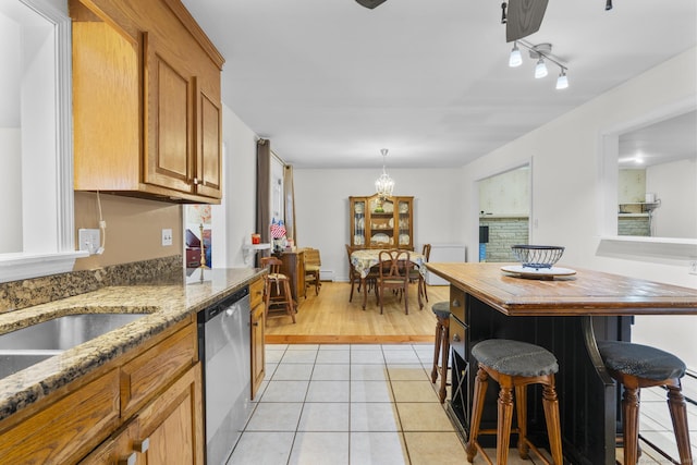 124 Pulaski Hwy, Ansonia, CT 06401 - kitchen with stainless steel dishwasher, light tile patterned flooring, a chandelier, light stone counters, and a breakfast bar area