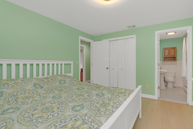 37 Cedar Ln, Beacon Falls, CT 06403 - bedroom with light wood-type flooring, a closet, ensuite bathroom, and tile walls