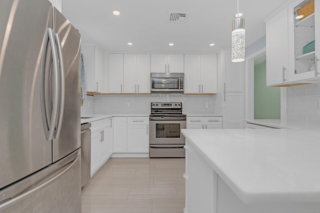 37 Cedar Ln, Beacon Falls, CT 06403 - kitchen featuring appliances with stainless steel finishes, decorative backsplash, light countertops, white cabinets, and glass insert cabinets