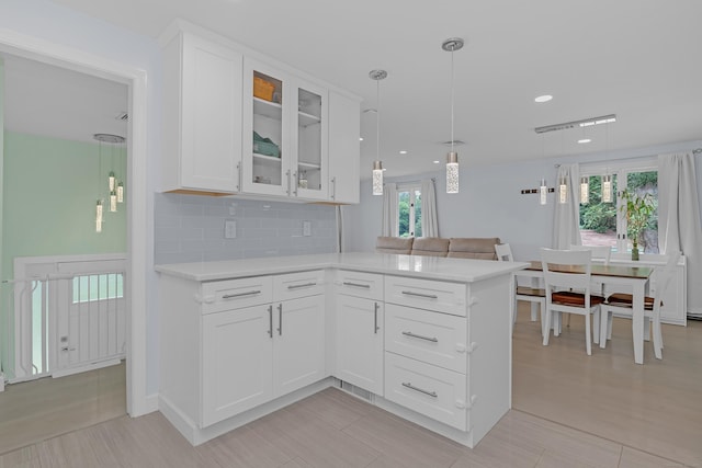37 Cedar Ln, Beacon Falls, CT 06403 - kitchen with light countertops, glass insert cabinets, white cabinetry, backsplash, and a peninsula