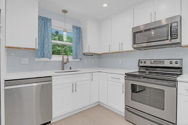 37 Cedar Ln, Beacon Falls, CT 06403 - kitchen with appliances with stainless steel finishes, light countertops, white cabinetry, decorative light fixtures, and tasteful backsplash