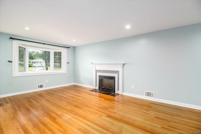 234 Forest Dr, Wethersfield, CT 06109 - unfurnished living room with light wood-style floors, a tiled fireplace, and recessed lighting