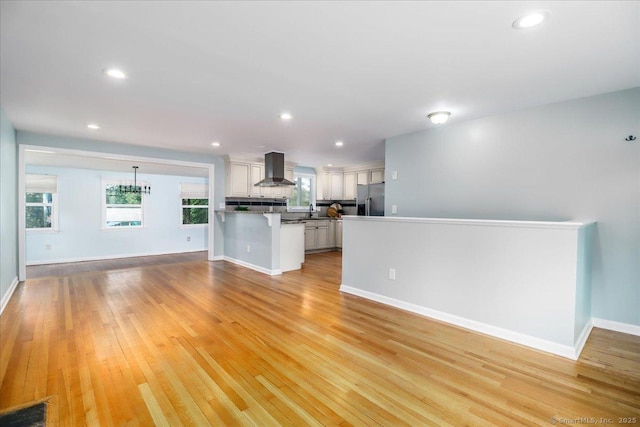 234 Forest Dr, Wethersfield, CT 06109 - unfurnished living room featuring light wood-style floors, recessed lighting, and plenty of natural light