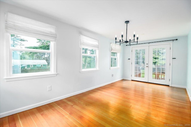 234 Forest Dr, Wethersfield, CT 06109 - unfurnished dining area with a chandelier, light wood-type flooring, and french doors