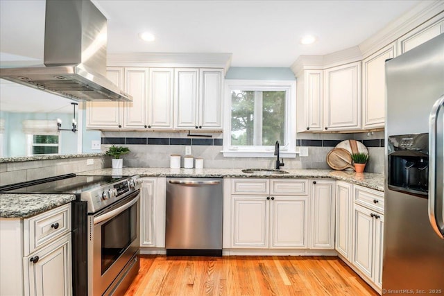 234 Forest Dr, Wethersfield, CT 06109 - kitchen with appliances with stainless steel finishes, wall chimney exhaust hood, tasteful backsplash, light wood finished floors, and light stone countertops