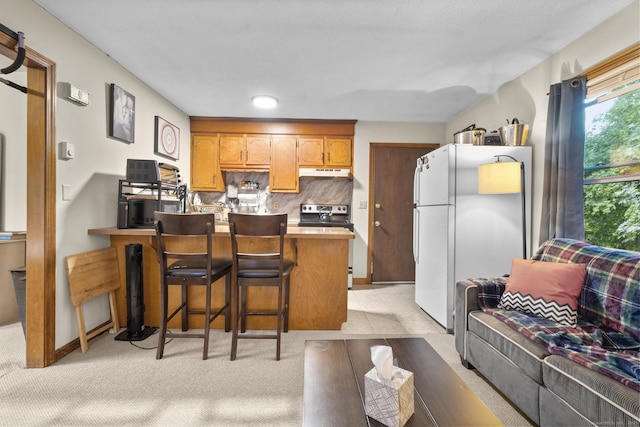 190 Main St, Plainfield, CT 06354 - kitchen featuring freestanding refrigerator, stainless steel electric range oven, under cabinet range hood, a peninsula, and light countertops