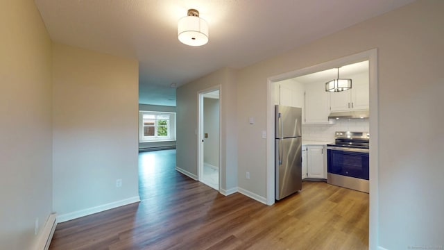 10 Cianci Ave Apt 9, Plainville, CT 06062 - kitchen with appliances with stainless steel finishes, under cabinet range hood, white cabinets, wood finished floors, and tasteful backsplash