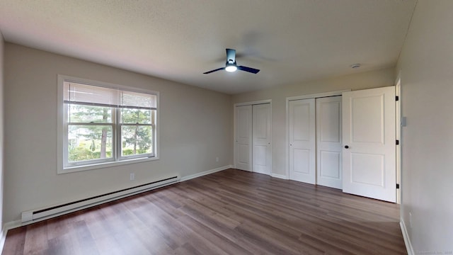 10 Cianci Ave Apt 9, Plainville, CT 06062 - unfurnished bedroom featuring a baseboard heating unit, multiple closets, wood finished floors, and a ceiling fan
