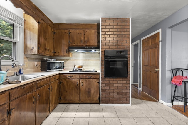 81 W Easton St, Hamden, CT 06514 - kitchen with black oven, stainless steel microwave, under cabinet range hood, tasteful backsplash, and light countertops