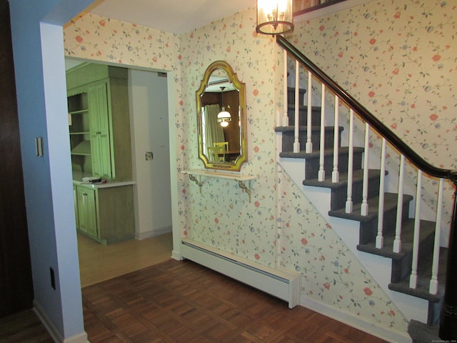 stairway featuring baseboard heating, wallpapered walls, and a chandelier