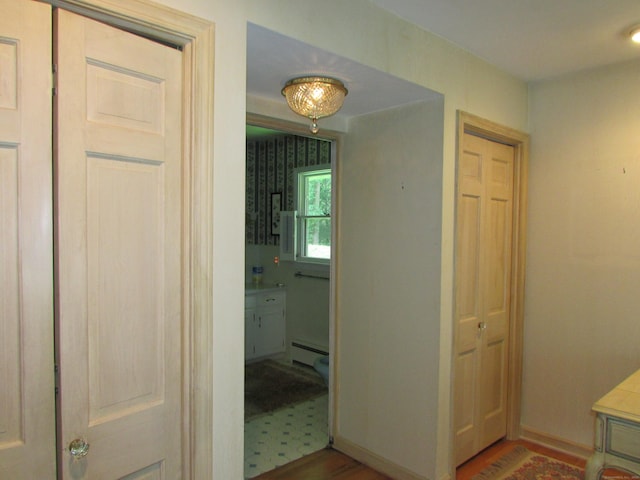 hall featuring a baseboard radiator and wood finished floors