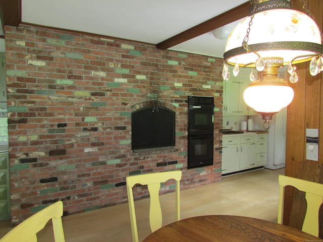 dining room featuring light wood-style floors and beamed ceiling