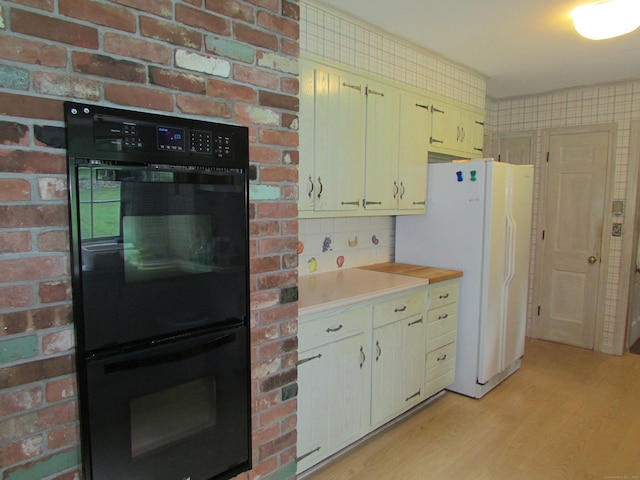 kitchen featuring light wood-type flooring, light countertops, and freestanding refrigerator