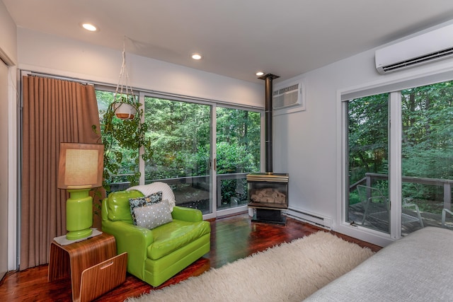 96 Sherman Rd, New Milford, CT 06776 - bedroom with a wall mounted AC, a wood stove, baseboard heating, wood finished floors, and recessed lighting