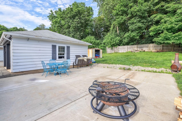 36 School St, Killingly, CT 06239 - fenced backyard featuring an outdoor fire pit, outdoor dining area, a patio area, and an outdoor structure