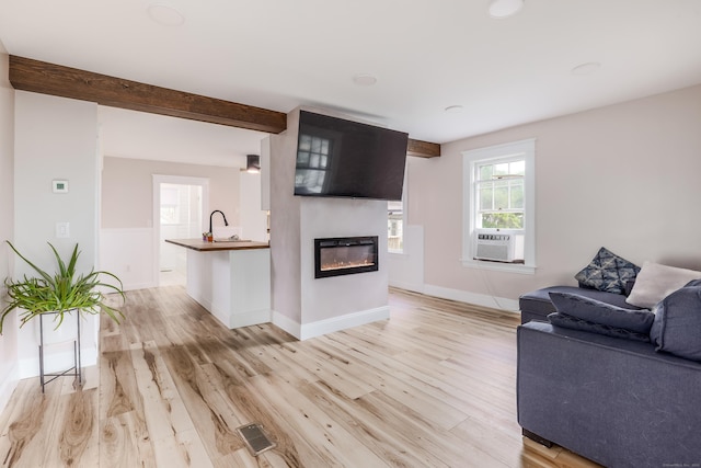 36 School St, Killingly, CT 06239 - living area featuring cooling unit, light wood finished floors, and a glass covered fireplace