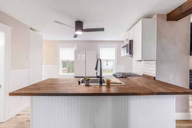 36 School St, Killingly, CT 06239 - kitchen featuring butcher block countertops, stainless steel microwave, freestanding refrigerator, decorative backsplash, and light wood finished floors
