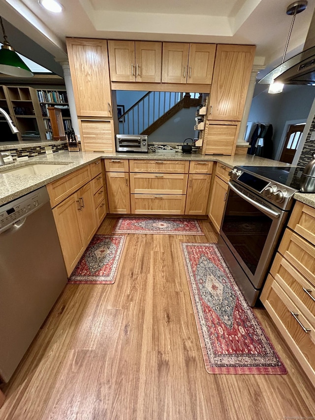 38 Tanglewood Rd, Farmington, CT 06032 - kitchen with appliances with stainless steel finishes, light wood-type flooring, light brown cabinets, range hood, and light stone counters