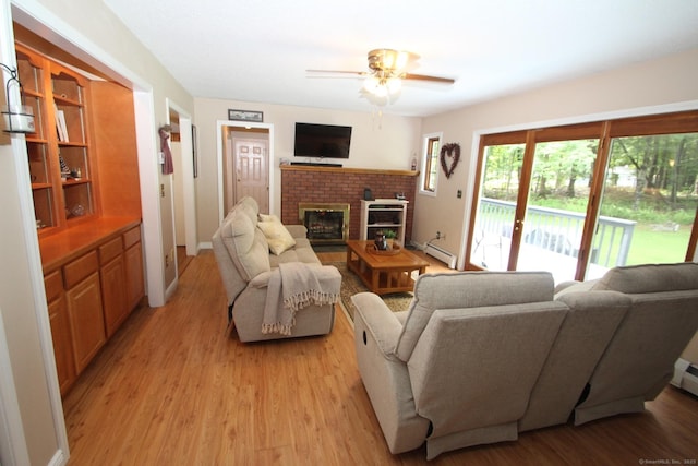46 Ryan Rd, Tolland, CT 06084 - living area with a baseboard radiator, a fireplace, light wood finished floors, and a ceiling fan